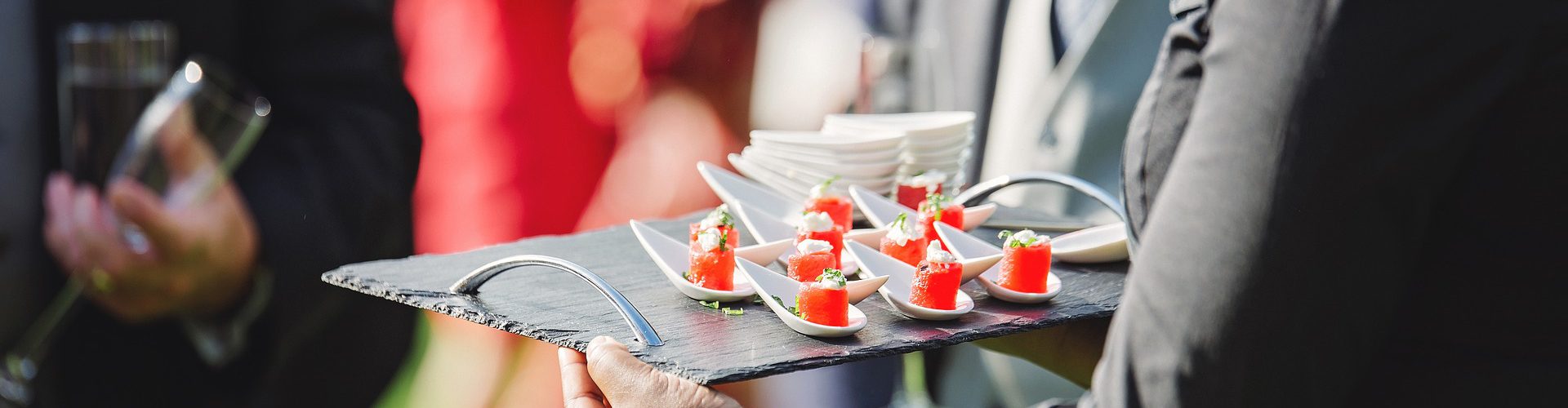 Waiter serving canapes in garden